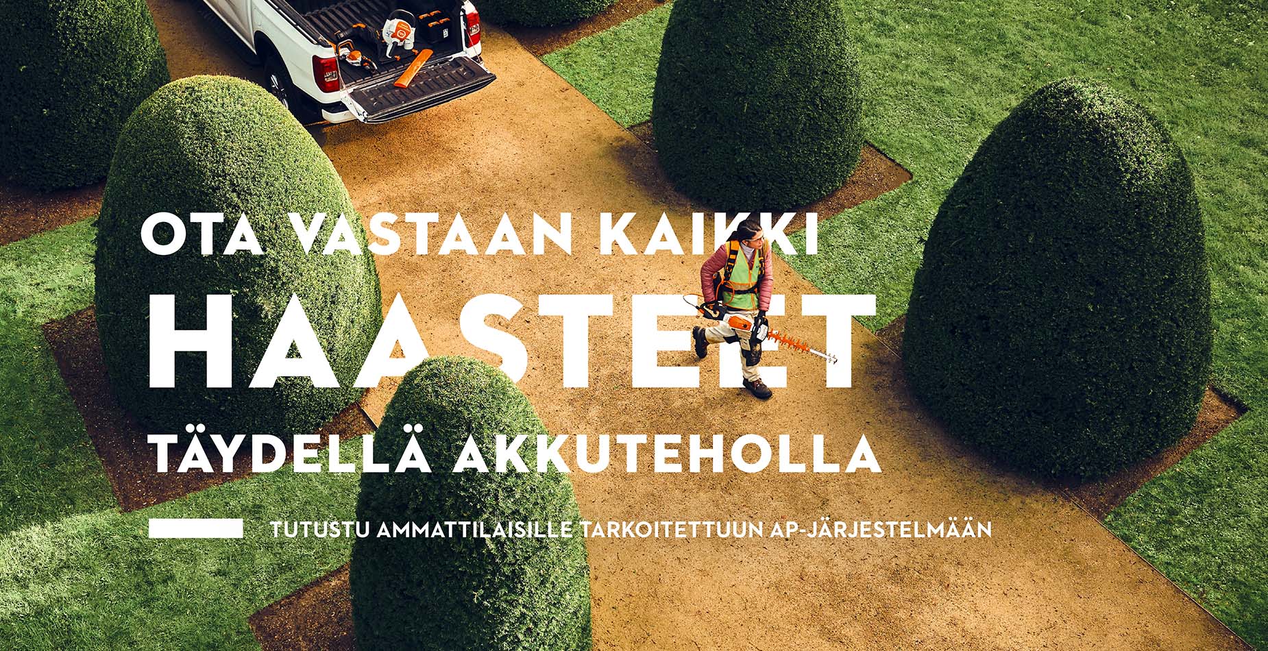 Kolme ammattilaista työskentelemässä STIHL-akkutyökaluilla lastausalueella, kun STIHL-varusteita käyttävä nainen leikkaa pensasaitaa taustalla 